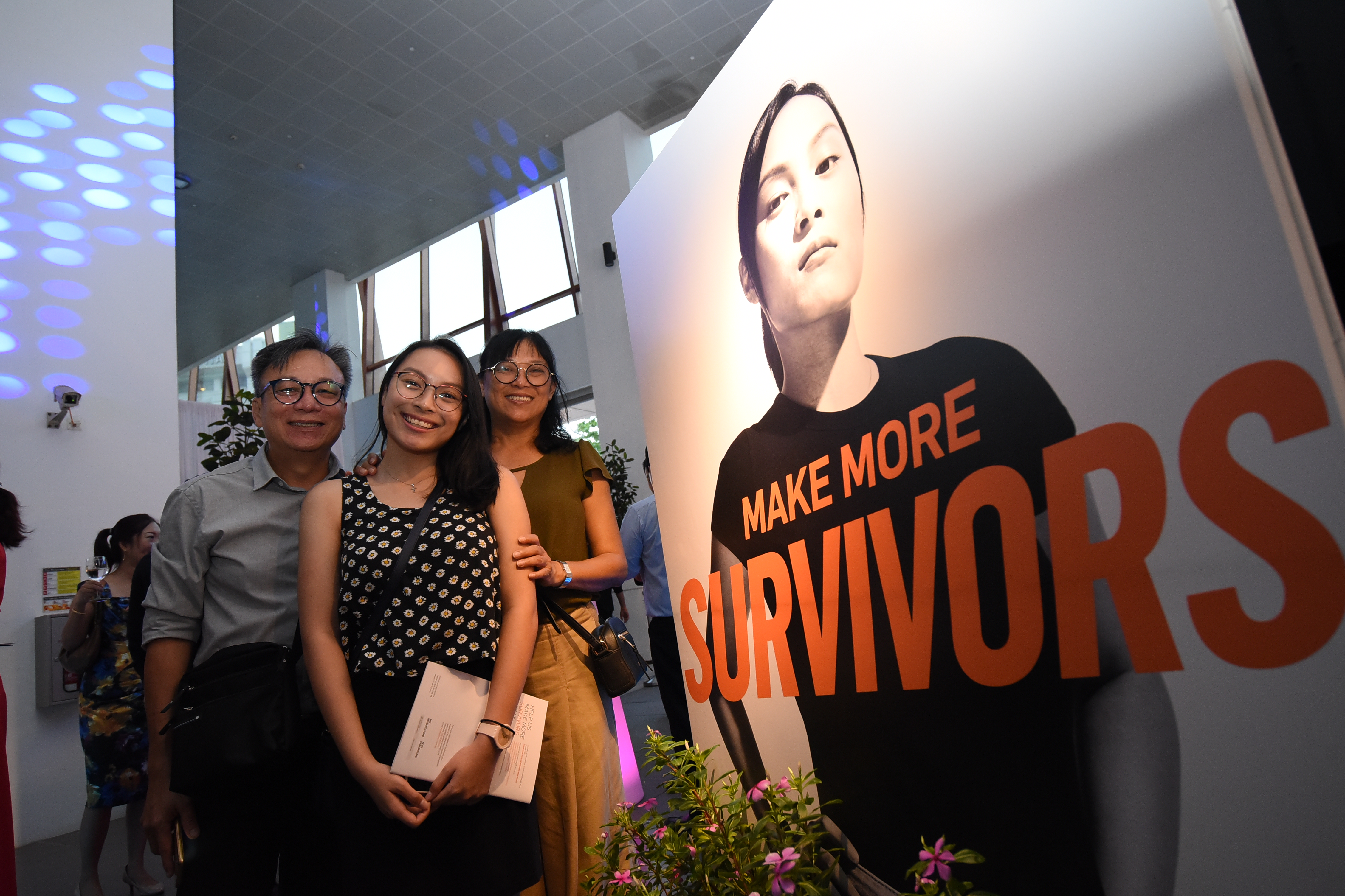  ​Survivor Ambassador, Ms Chong Hui Min poses with her parents at the Launch Event 